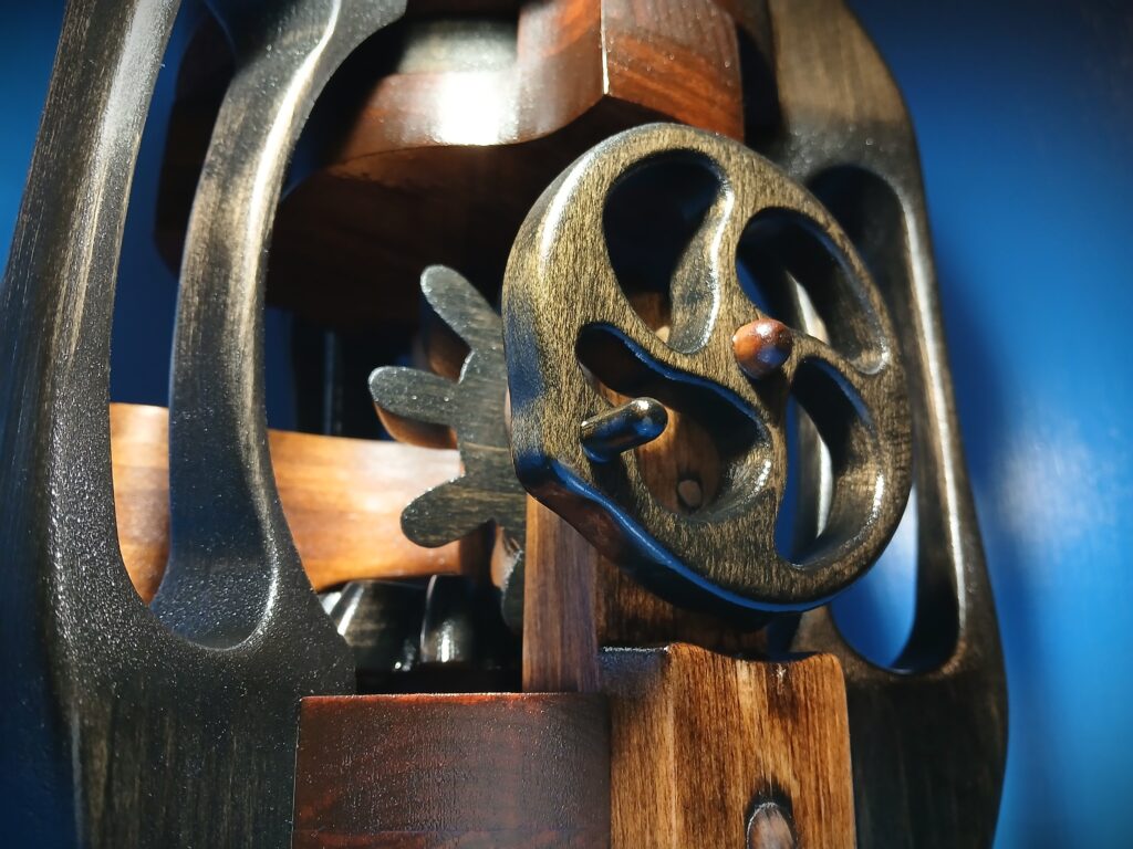 Close-up of an ornate, antique brass keyhole on a wooden surface.