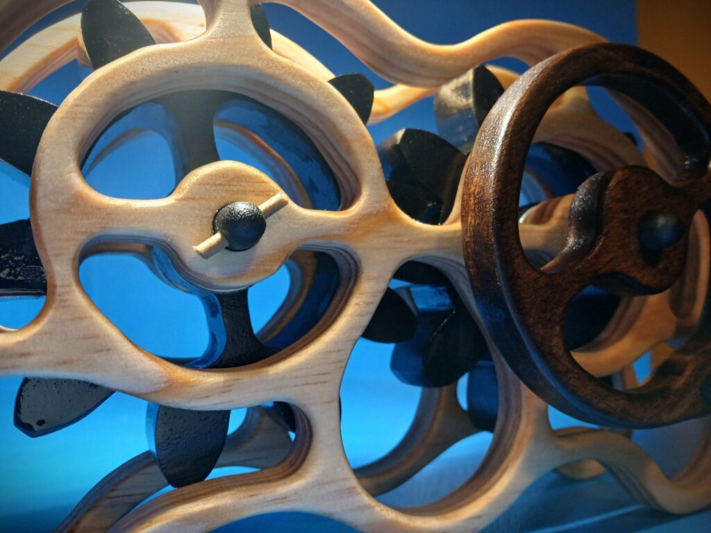 Close-up of intertwined metallic valve wheels with a blue background.